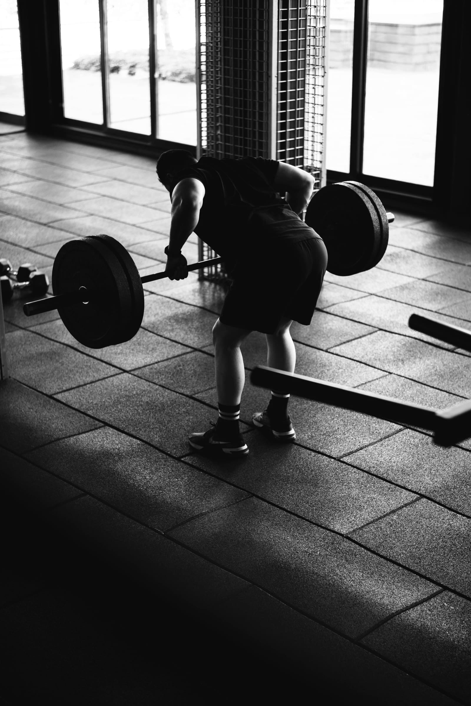 Squat lourd à la barre dans une salle vide