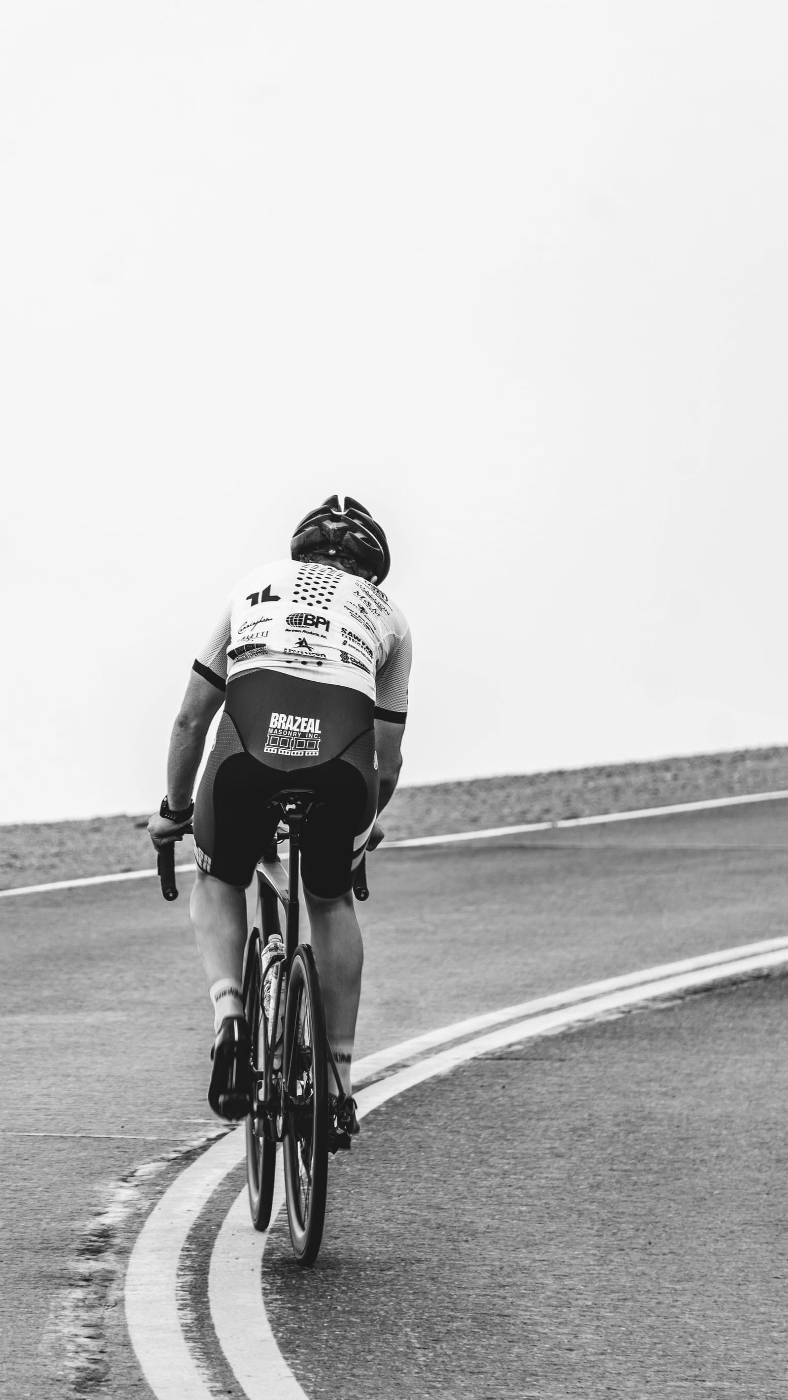 Cycliste de dos sur une route rase et déserte
